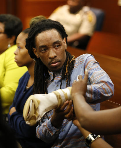 Burn victim Anthony Gooden gets help with his injured hand during a break in a trial for Martin Blackwell in Atlanta, Wednesday, Aug. 24, 2016. Blackwell is accused of pouring hot water on Gooden and his friend as they slept. (AP Photo/John Bazemore)
